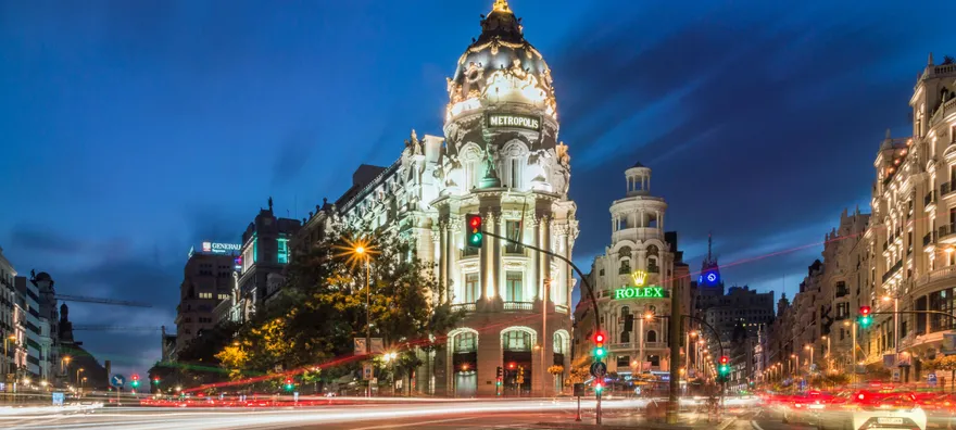 Vista nocturna del Edificio Metrópolis en el centro de Madrid, representando el núcleo urbano y el alto coste de vida que impulsa la inversión inmobiliaria hacia las zonas rurales cercanas en busca de mayor rentabilidad.